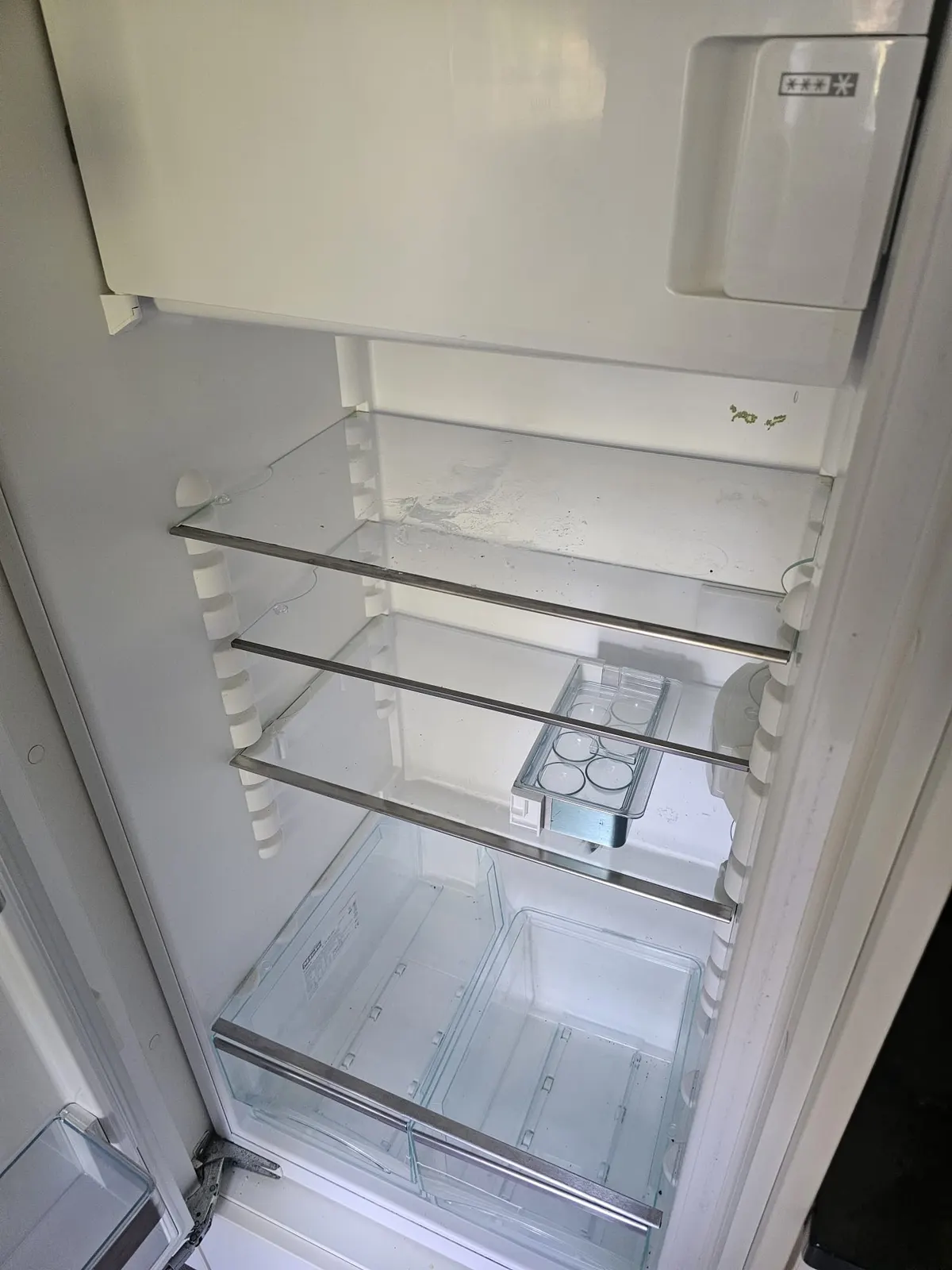 Kühlschrank vor der Reinigung, mit Flecken auf den Ablagen