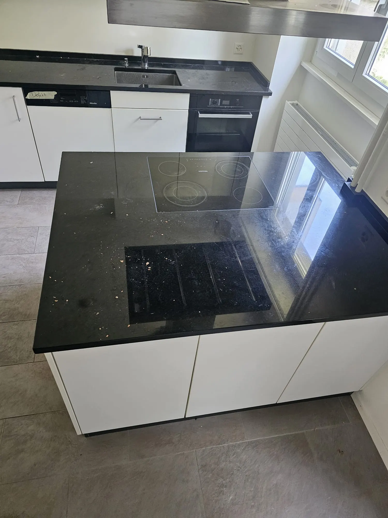 Kochinsel vor der Reinigung, mit Krümeln und Staub